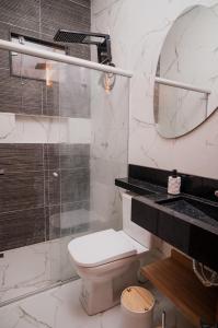 e bagno con servizi igienici, doccia e specchio. di Bela casa de temporada em Alcobaça BA ad Alcobaça