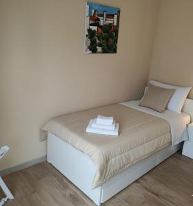 a small bedroom with a bed with towels on it at Etna Charme Guest House in Belpasso