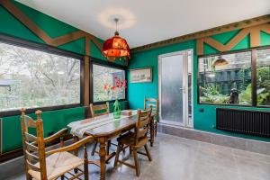 Un comedor con paredes verdes y una mesa y sillas de madera. en Chalet Green, en Tiflis