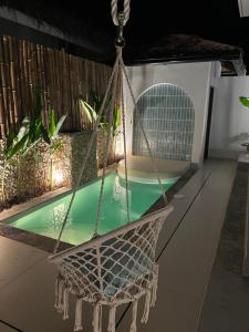 a hammock is hanging over a swimming pool at Alma Villas in Paliton +25 photos