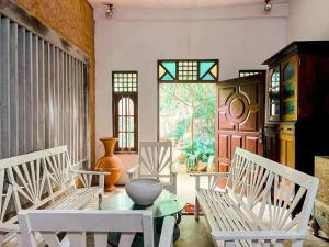 a room with white chairs and a table and a window at Derana Villa in Hikkaduwa