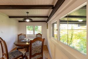a dining room with a table and chairs and a window at Hiša Jaglenka in Ponikva