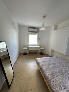 a white room with a bed and a window at Beach apartment on Nitsa street in Netanya +2 photos