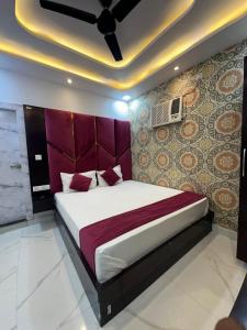 Un dormitorio con una cama grande con cabecero morado. en Hotel Peepal Tree Prayagraj, en Prayagraj