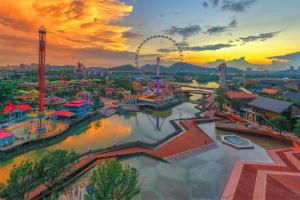 einen Vergnügungspark mit einem Riesenrad bei Sonnenuntergang in der Unterkunft Wanlin International Hotel in Foshan