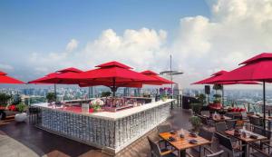 ein Restaurant mit roten Sonnenschirmen auf dem Dach eines Gebäudes in der Unterkunft Wanlin International Hotel in Foshan