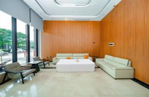 ein Wohnzimmer mit Sofa, Tisch und Stühlen in der Unterkunft Wanlin International Hotel in Foshan + 57 Fotos