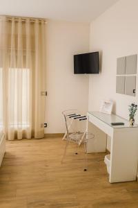 a white room with a desk and a table at Etna Charme Guest House in Belpasso