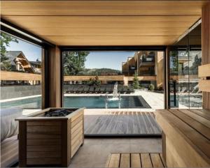 an open living room with a pool and a house at Giewont View Sośnica Residence & Spa in Zakopane +3 photos