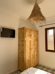 1 dormitorio con armario de madera y TV en la pared en Palais Taroudant, en Taroudant
