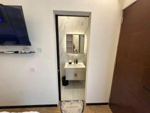 une salle de bains avec un lavabo et un miroir dans l'établissement villa koku kuta, à Legian