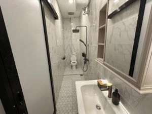 une salle de bains avec lavabo, douche et toilettes dans l'établissement villa koku kuta, à Legian