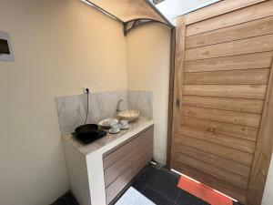 une pièce avec une porte en bois et un comptoir avec des casseroles et des poêles dans l'établissement villa koku kuta, à Legian