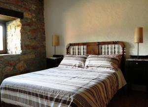 a bed in a bedroom with two lamps on tables at Ruralmedulas Casa 1 in Carucedo
