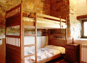 a bedroom with bunk beds in a stone wall at Ruralmedulas Casa 1 in Carucedo