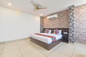 Un dormitorio con una cama y una pared de ladrillo. en Hotel Neelambar Villa, en Jaipur