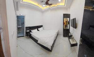 Un dormitorio pequeño con una cama y un espejo. en Hotel Peepal Tree Prayagraj, en Prayagraj