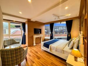 um quarto de hotel com uma cama e uma janela grande em Park Woods At Mall Road em Mussoorie