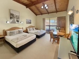 1 dormitorio con 2 camas, mesa y comedor en Coonawarra Place Motor Inn, en Coonawarra