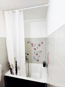 une baignoire blanche avec un rideau de douche à fleurs dans l'établissement Sweet Home Relax Badalucco, à Badalucco