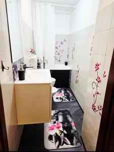 La salle de bains est pourvue d'un lavabo et de toilettes fleuries. dans l'établissement Sweet Home Relax Badalucco, à Badalucco 24 autres photos