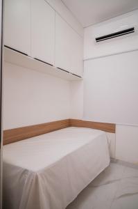 una camera bianca con letto e armadi bianchi di Bela casa de temporada em Alcobaça BA ad Alcobaça