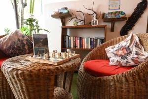 a living room with wicker chairs and a chess set on a chess board at Bulskamp Inn in El Nido