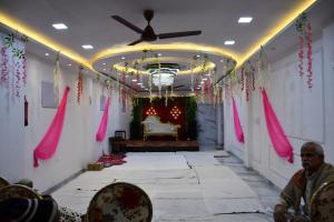 a hall with pink decorations and a couch in a room at Hotel Peepal Tree Prayagraj in Prayagraj