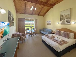Un dormitorio con una cama y una sala de estar. en Coonawarra Place Motor Inn, en Coonawarra