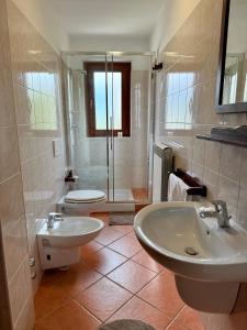 ein Badezimmer mit zwei Waschbecken, einer Toilette und einer Dusche in der Unterkunft Case Vacanza Perron in Sauze dʼOulx