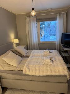 Un dormitorio con una gran cama blanca con ventana. en Santa's Family Villa, en Rovaniemi