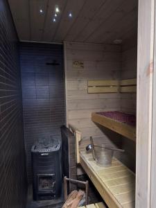 una sauna con estufa y horno sobre la estufa en Santa's Family Villa, en Rovaniemi 19 fotos más