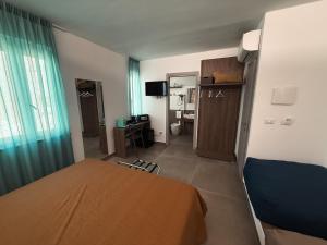 a bedroom with a bed and a desk and a mirror at my Vesta Suites in Vieste