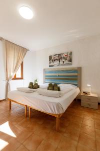 ein großes Schlafzimmer mit einem großen Bett mit weißer Bettwäsche in der Unterkunft Residence Rustico in Garda + 282 Fotos