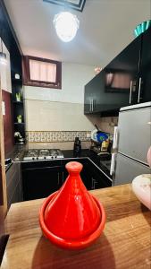 a red vase sitting on a wooden table in a kitchen at Appartement au centre de TIZNIT in Tiznit +13 photos
