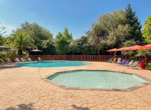 einen Pool im Garten mit Stühlen und Sonnenschirmen in der Unterkunft Camping 3 étoiles - Parc aquatique - ccba0ec in Urt + 8 Fotos