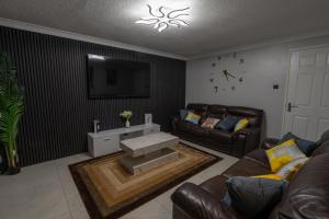 un salon avec un canapé et une télévision dans l'établissement Charming 2 Bedroom luxurious Home in Thamesmead south east London, à North Woolwich