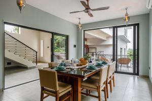 a dining room with a wooden table and chairs at SaffronStays Eden Greens in Calangute