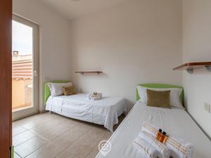 due letti in una stanza con finestra di House Afrodite a San Vero Milis Altre 18 foto