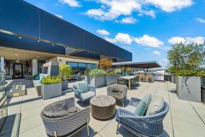 a patio with chairs and tables on a building at Stylish Condo Mins to Shoreline in Long Beach