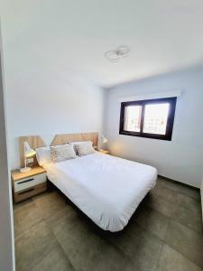 une chambre avec un lit blanc et une fenêtre dans l'établissement Casa Alba, à San Juan de los Terreros