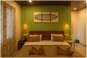 a bedroom with a bed with two bows on it at Lagoon Stays, Gokarna in Gokarna