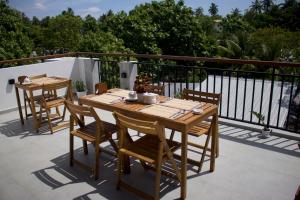 a wooden table and chairs on a balcony at Oshi Boutique in Felidhoo