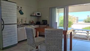 eine Küche mit einem Holztisch und Stühlen darin in der Unterkunft Nautilus Self Catering in Yzerfontein + 5 Fotos