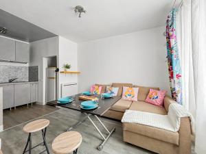 ein Wohnzimmer mit Sofa und Tisch in der Unterkunft Chez Alice, Appartement proche de Disneyland Paris in Montry
