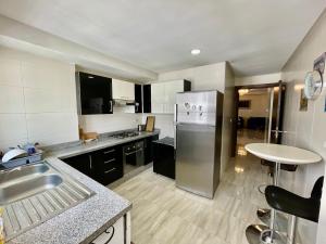 非斯Prestigia Fes Luxury Apartments的配有不锈钢冰箱和桌子的厨房