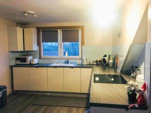 a kitchen with white cabinets and a sink and a window at The Wee Pad - Uk42918 in Dunfermline +16 photos