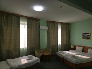 une chambre d'hôtel avec deux lits et une fenêtre dans l'établissement Hotel Expo, à Yunusobod 50 autres photos