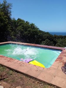 ein mit Wasser gefülltes Schwimmbecken neben dem Meer in der Unterkunft Great sea view, swimming pool, braai, wi-fi in Port Shepstone