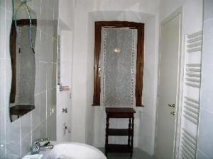 ein weißes Badezimmer mit Waschbecken und Fenster in der Unterkunft Ferienwohnung für 4 Personen ca 50 m in Miasino, Piemont Ortasee in Miasino + 2 Fotos